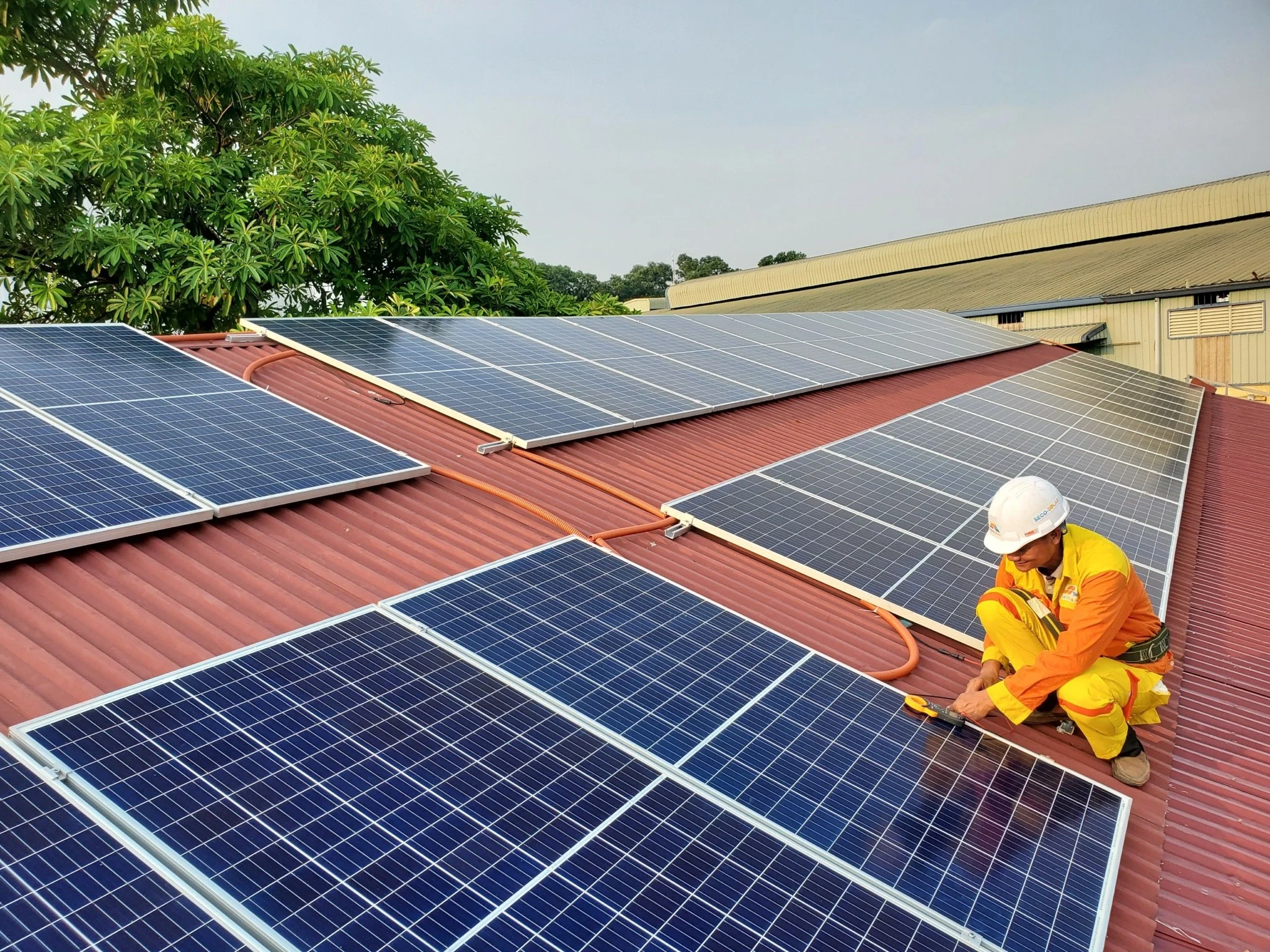 Solar panel installer at work on a roof